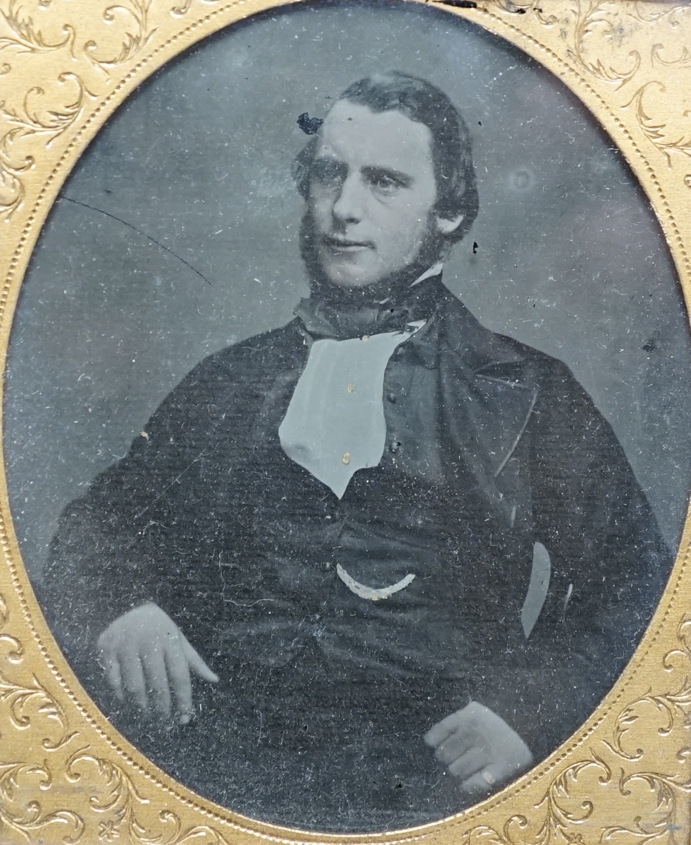 A mid Victorian ambrotype photograph of a gentleman, housed in an original pressed bois durci fireman frame, 9.5cm high. Condition - good